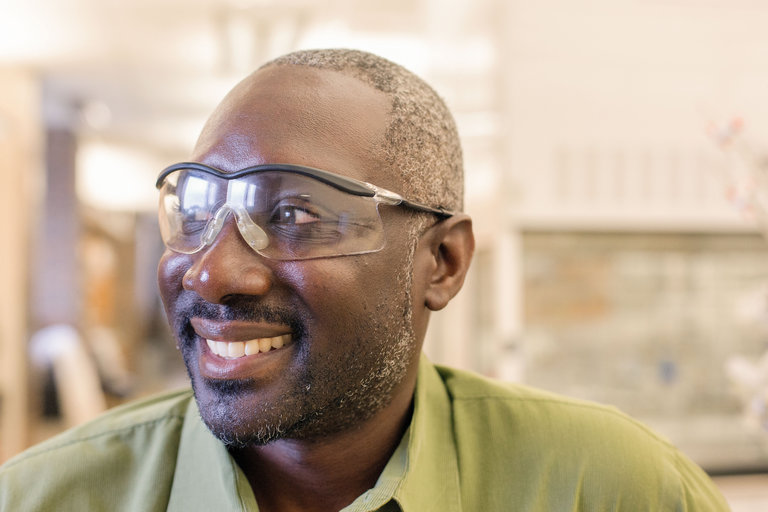 smiling black man wearing protective lab glasses