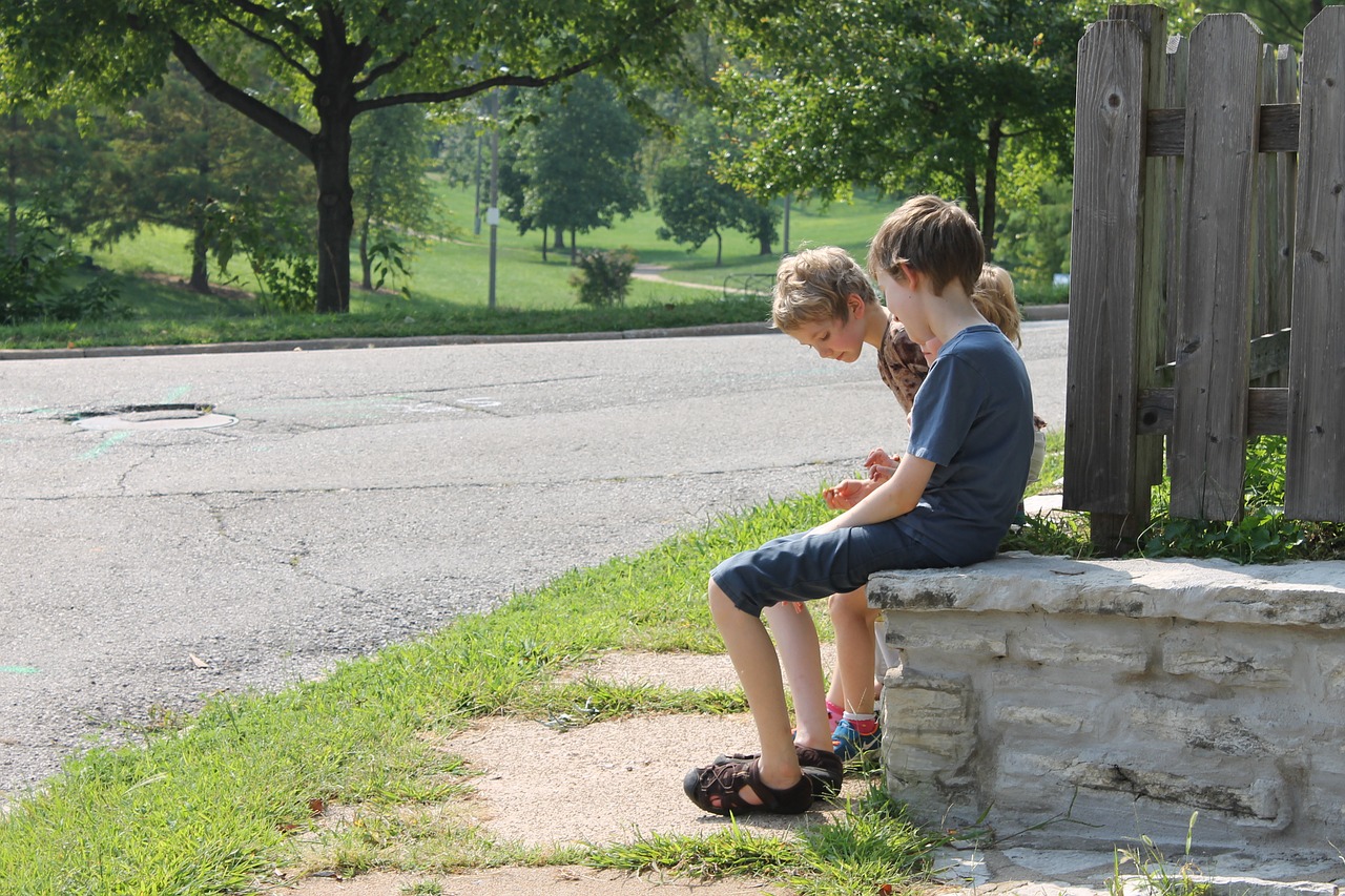 3 little boys sitting on a wall